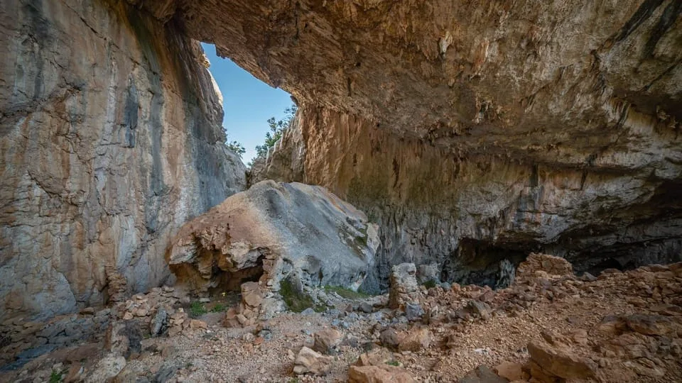 The collapsed limestone vault of the Tiscali sinkhole, with scrub growing below the overhang